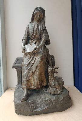 a statue of a woman sitting on a bench with a dog