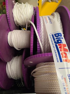 un bac violet rempli de corde et d'une paire de ciseaux