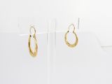 a pair of gold hoop earrings on a clear display stand