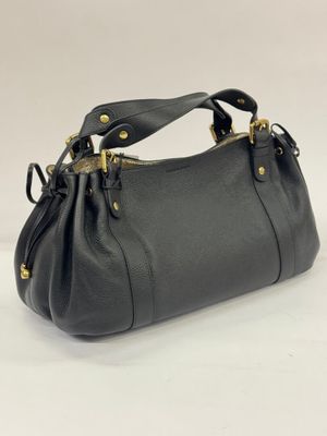 a black handbag with gold hardware on the handles