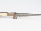 un vieux couteau avec un manche en bois sur une surface blanche