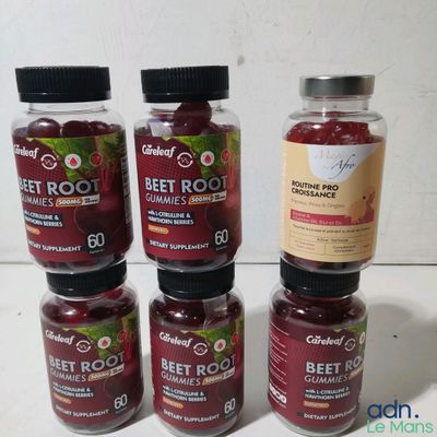 four jars of beet root sit on a table next to a bottle of beet root