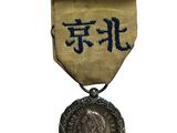 une vieille médaille sur laquelle figure une inscription en chinois et qui est entourée d'un ruban
