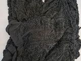 un haut de soutien-gorge noir posé sur une surface blanche