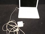 a white laptop computer sitting on a table with a charger attached to it