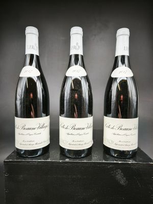 trois bouteilles de vin sont alignées sur une boîte noire