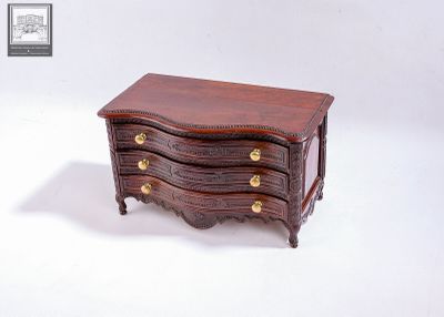 une petite commode en bois sur fond blanc
