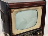 un téléviseur à l'ancienne posé sur une surface blanche