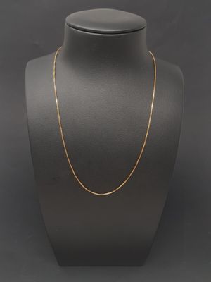 a gold chain necklace on a mannequin neck