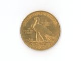 a gold coin with a bird on it on a white surface
