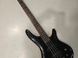 une guitare basse noire posée sur une table