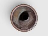a brown vase with a hole in it on a white surface