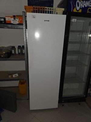 a refrigerator in a room with a lot of items on the shelves