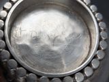 a close up of a silver vase with writing on it