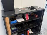 a black book shelf with a laptop on top of it