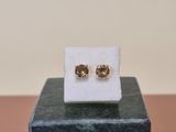 a close up of a pair of earrings sitting on top of a marble block