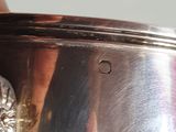 someone is holding a silver cup with a flower on it