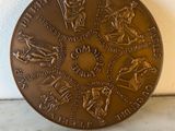 an image of a bronze medal with a map of the world on it