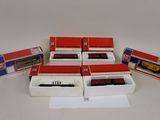 six boîtes contenant des trains miniatures, posées sur une table