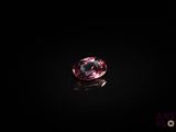 a close up of a pink diamond on a black surface