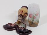 un vase cassé et une paire de chaussures posés sur une table