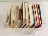 un bac en plastique rempli de nombreux livres posé sur une table