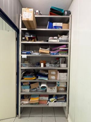 a room with a lot of boxes and papers on the shelves