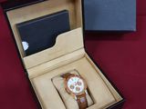 an image of a watch in a box on a red surface