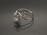 une bague en or blanc sertie d'une topaze bleue au centre