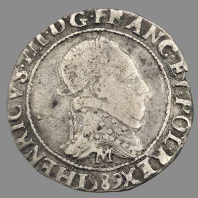 un gros plan d'une pièce d'argent sur laquelle figure l'effigie d'une femme