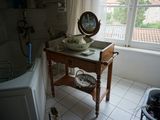 une petite table sur laquelle est posé un miroir, dans une salle de bains