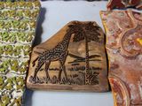 a giraffe and a palm tree carved into a piece of wood