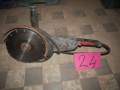 a broken drill on the floor next to a pink sign