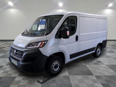 la camionnette blanche est garée sur un sol carrelé en damier
