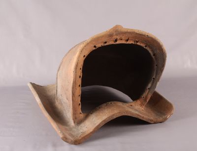 un petit objet en bois posé sur une surface blanche