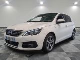 la voiture blanche est garée sur un sol en damier dans le garage
