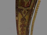 painting on the back of a wooden chair with a gold and red design