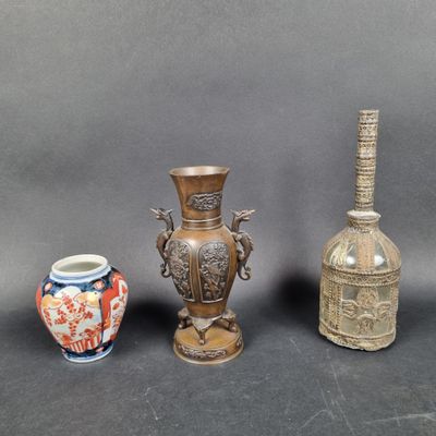 trois vases et une bouteille posés les uns à côté des autres sur une table