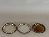 three small dishes sitting on top of a white table next to each other
