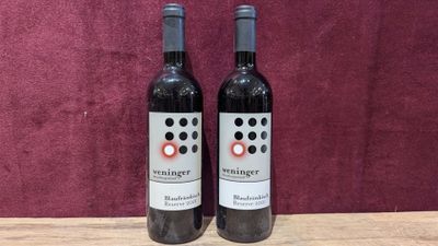 two bottles of wine sitting on top of a wooden table