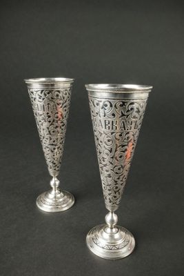 deux vases en argent posés l'un à côté de l'autre sur une table