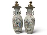 pair of chinese vases with figures on them on a white background