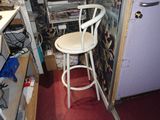 a white bar stool in a room with a red carpet