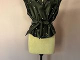 veste en cuir noir sur un mannequin, ornée de perles et d'un nœud papillon