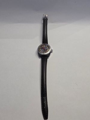 une photo d'une montre posée sur une surface blanche