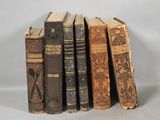 several old books are stacked on top of each other on a table