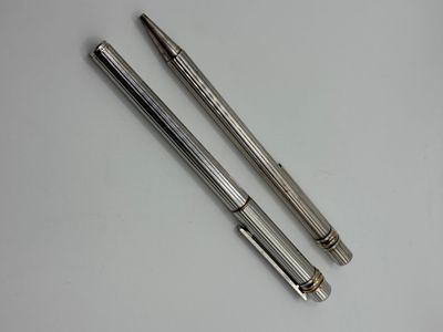 deux stylos métalliques posés l'un à côté de l'autre sur une surface blanche