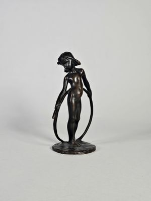 une statue en bronze représentant une femme tenant un cerceau dans ses mains
