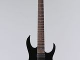 une guitare électrique noire suspendue à une ficelle sur un mur blanc