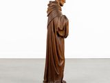 a wooden statue of a man in a brown robe